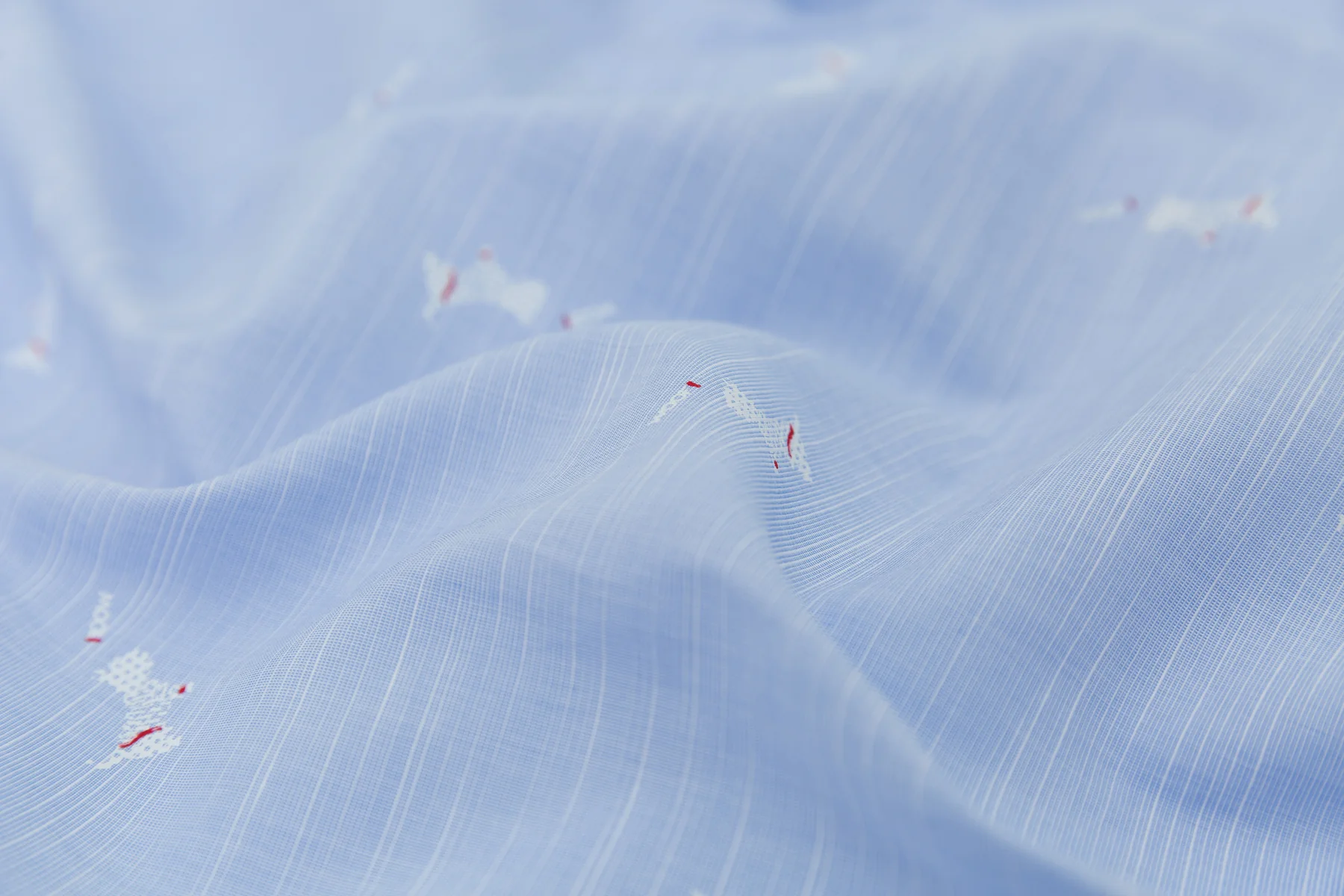 Close-up of light blue shirt fabric with embroidered detail